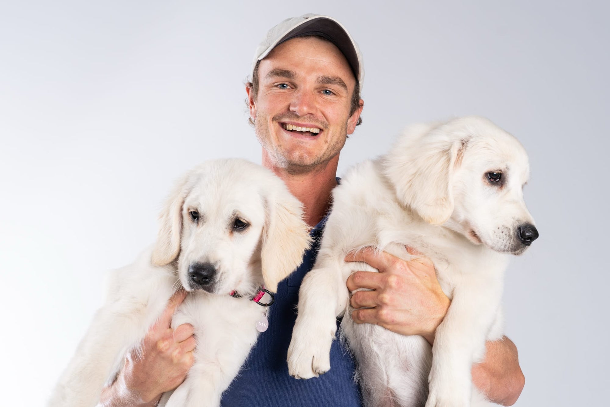 Will, founder of 5 Hounds, holding two puppies